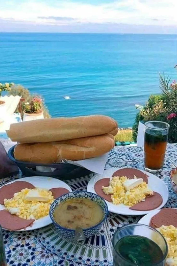 Bread and mint tea on a table with a sea view at Cafe Hafa in Tangier
