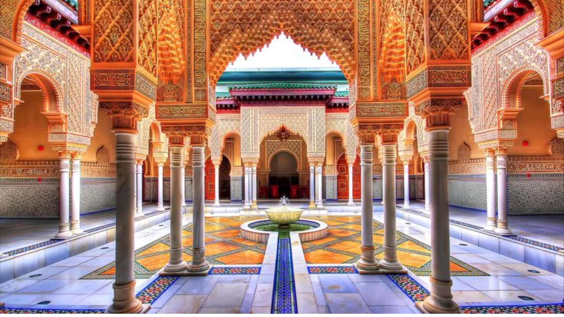 Courtyard with painted arches, zellige tilework and a central fountain in Marrakech