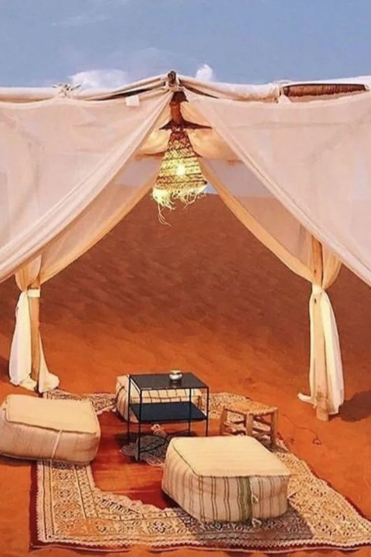 Luxury desert camp tent opening onto red sand dunes in Zagora
