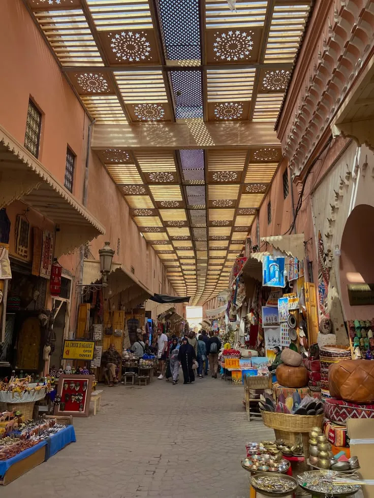 Covered souk street with a lattice roof and craft shops in the Marrakech medina