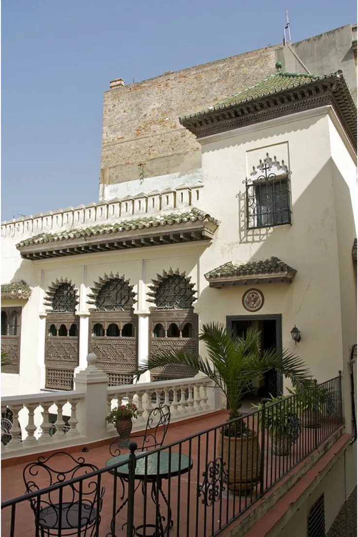 Moorish building with ornate carved windows and green-tiled eaves in Tangier