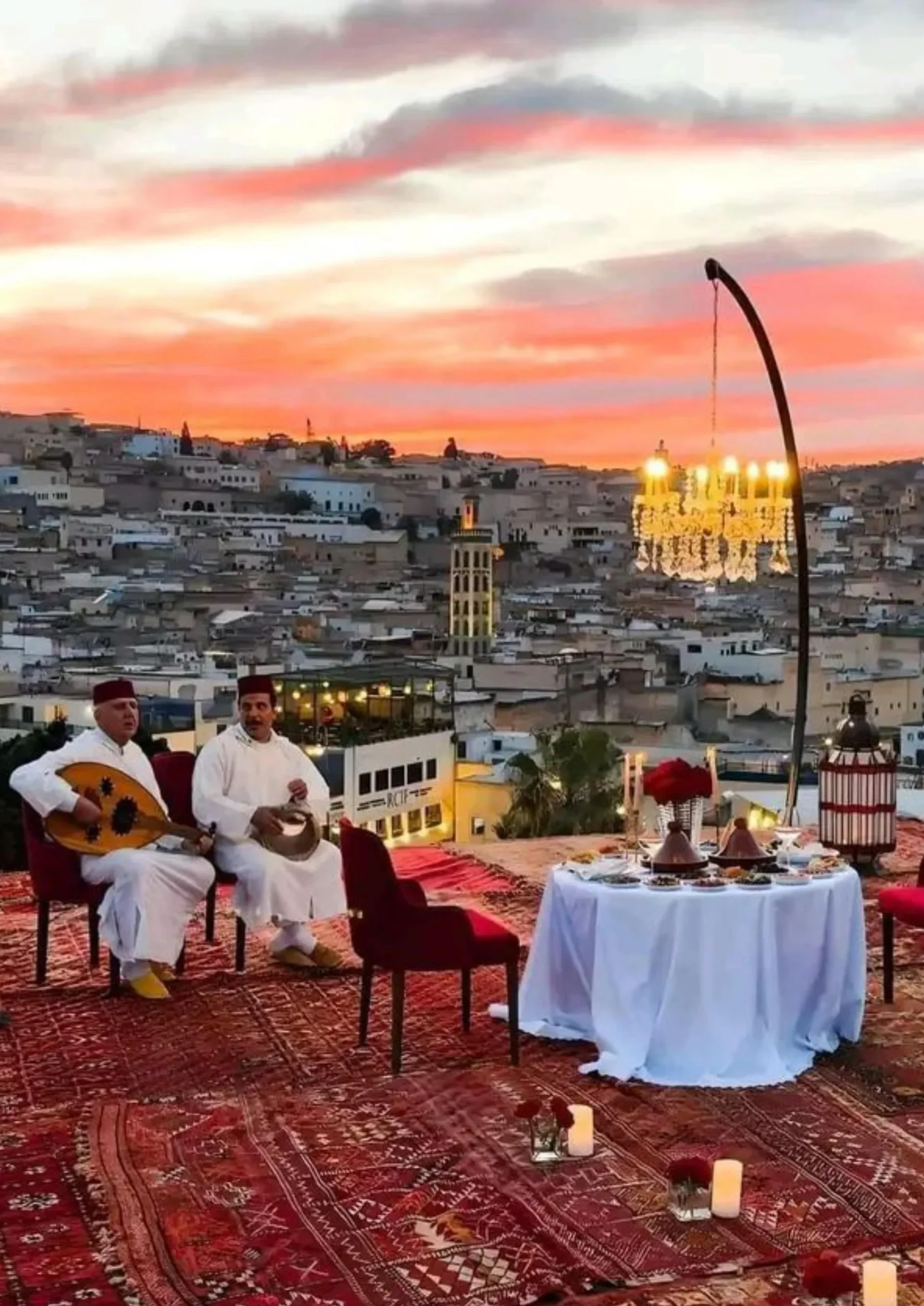 Musicians playing oud on a rooftop terrace overlooking the Fes medina at sunset
