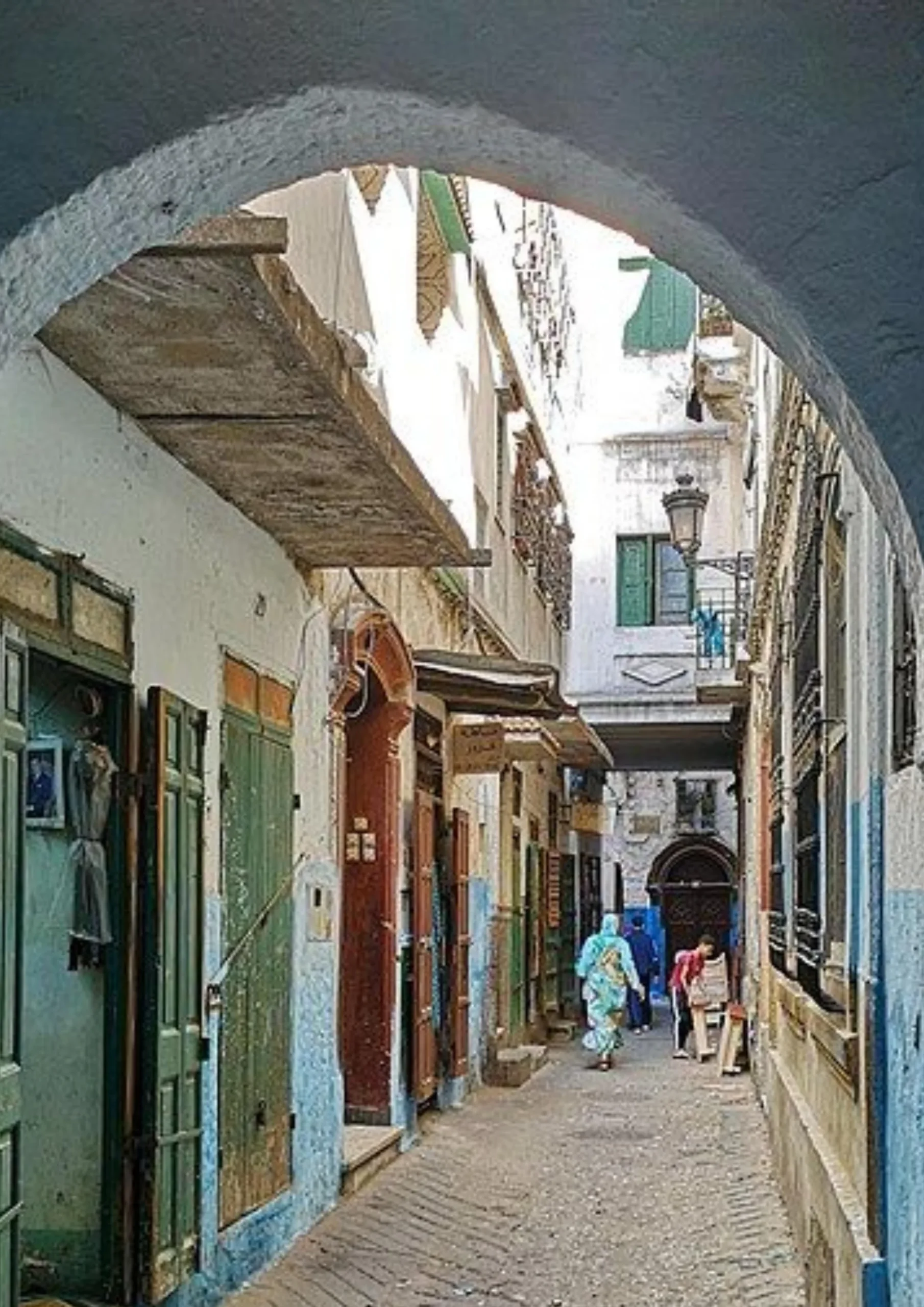 Narrow alley with green wooden doors in the Fes medina