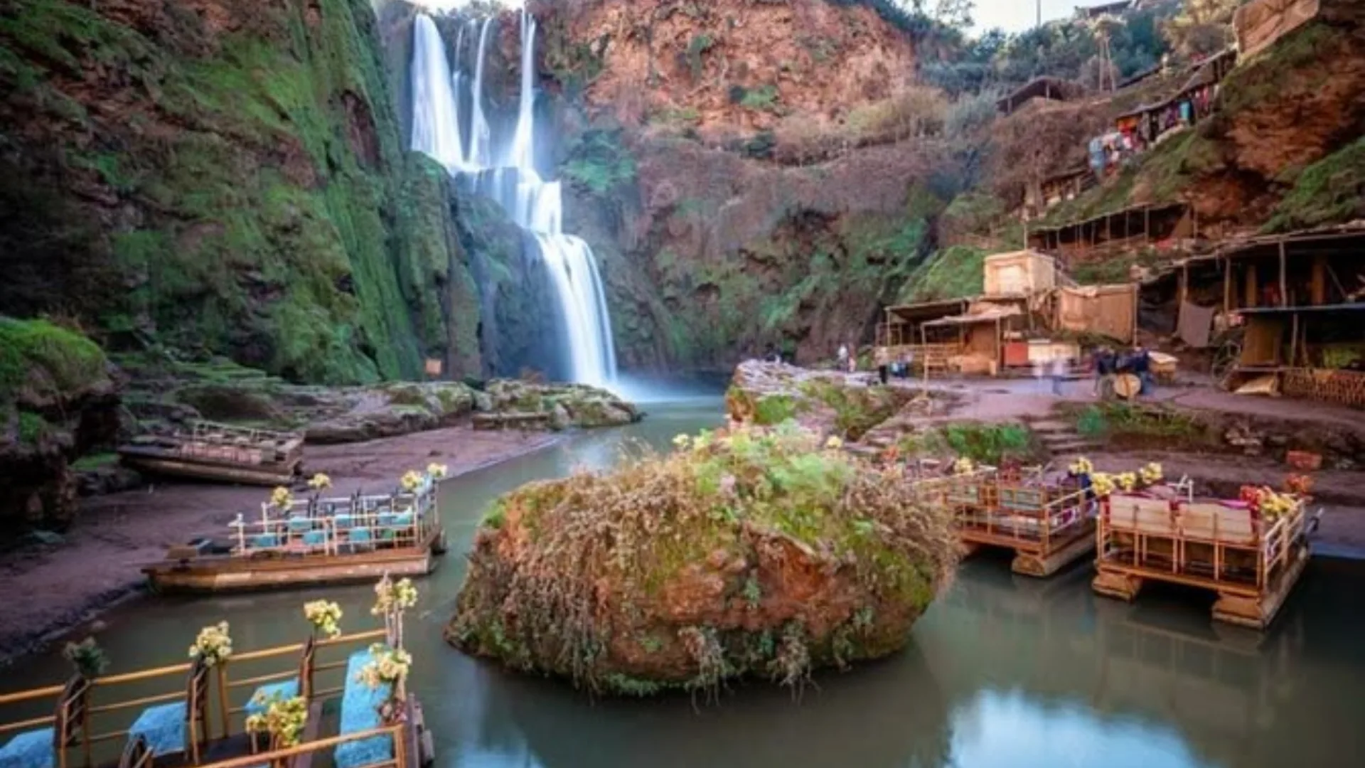 Ouzoud Waterfalls cascading beside riverside cafes and boats near Marrakech