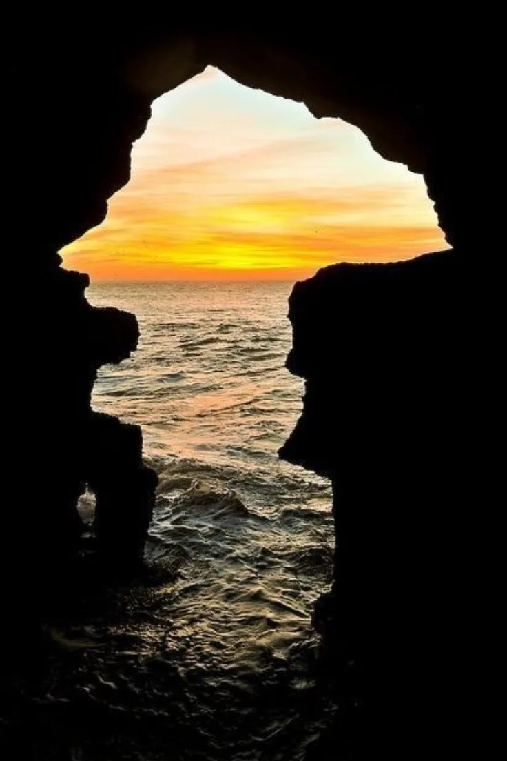 Sunset over the Atlantic framed by the rock opening of the Caves of Hercules near Tangier