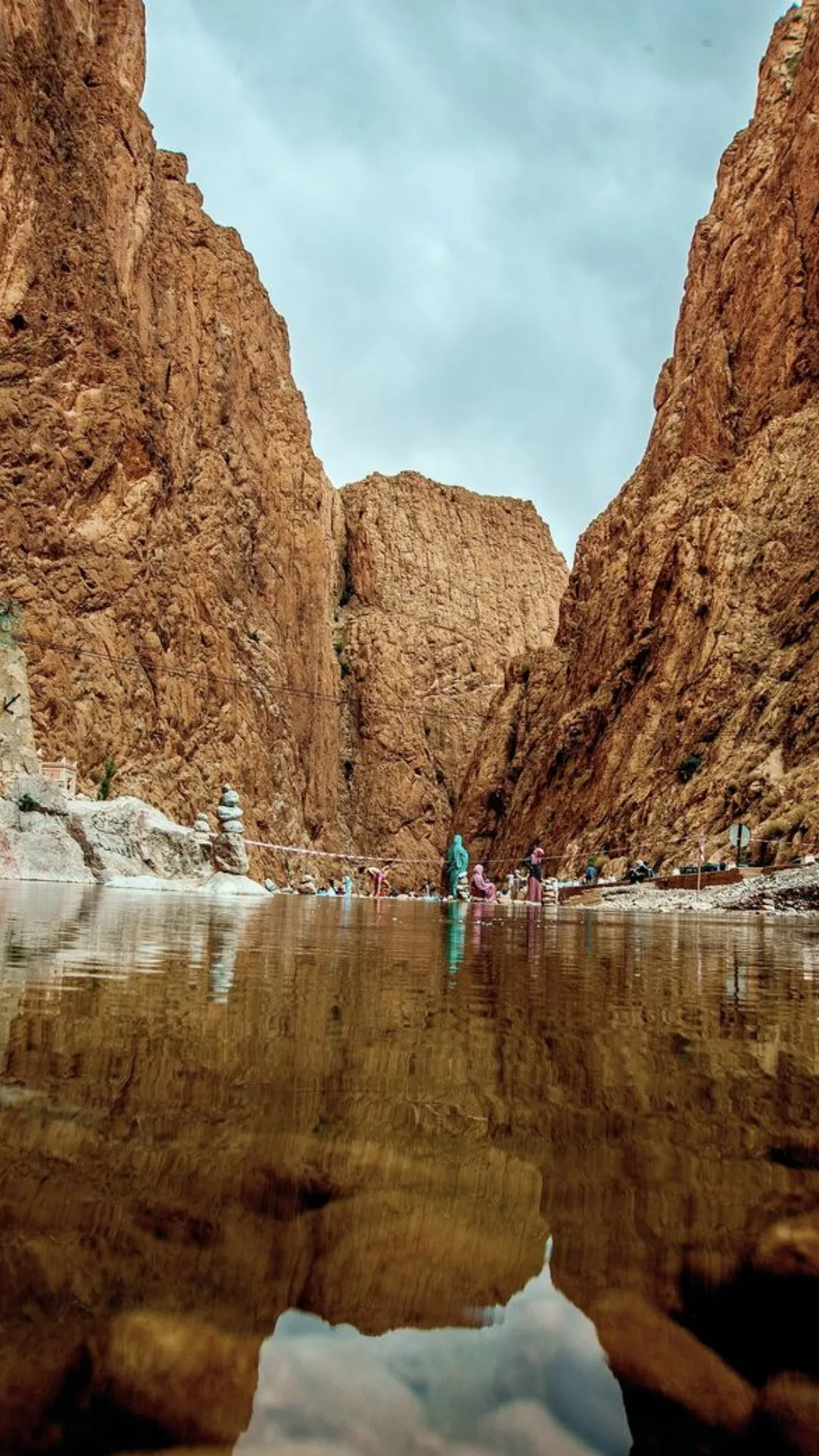 Visitors walking between the towering cliffs of Todra Gorge in Morocco